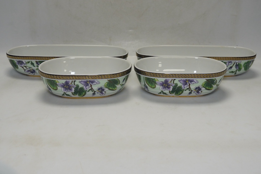 Six Rosenthal for Versace porcelain items; a boxed chocolate cup and saucer, four oblong serving dishes, longest 23cm, and a boxed miniature timepiece, 8.5cm high. Condition - good.